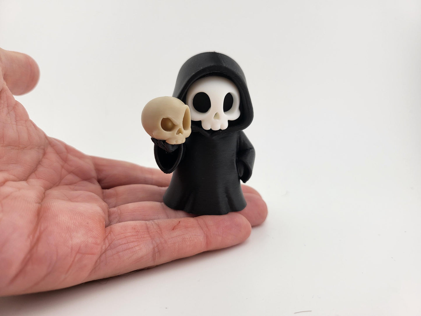 Sensenmann-Figur mit Schädel im Bücherregal arrangiert
