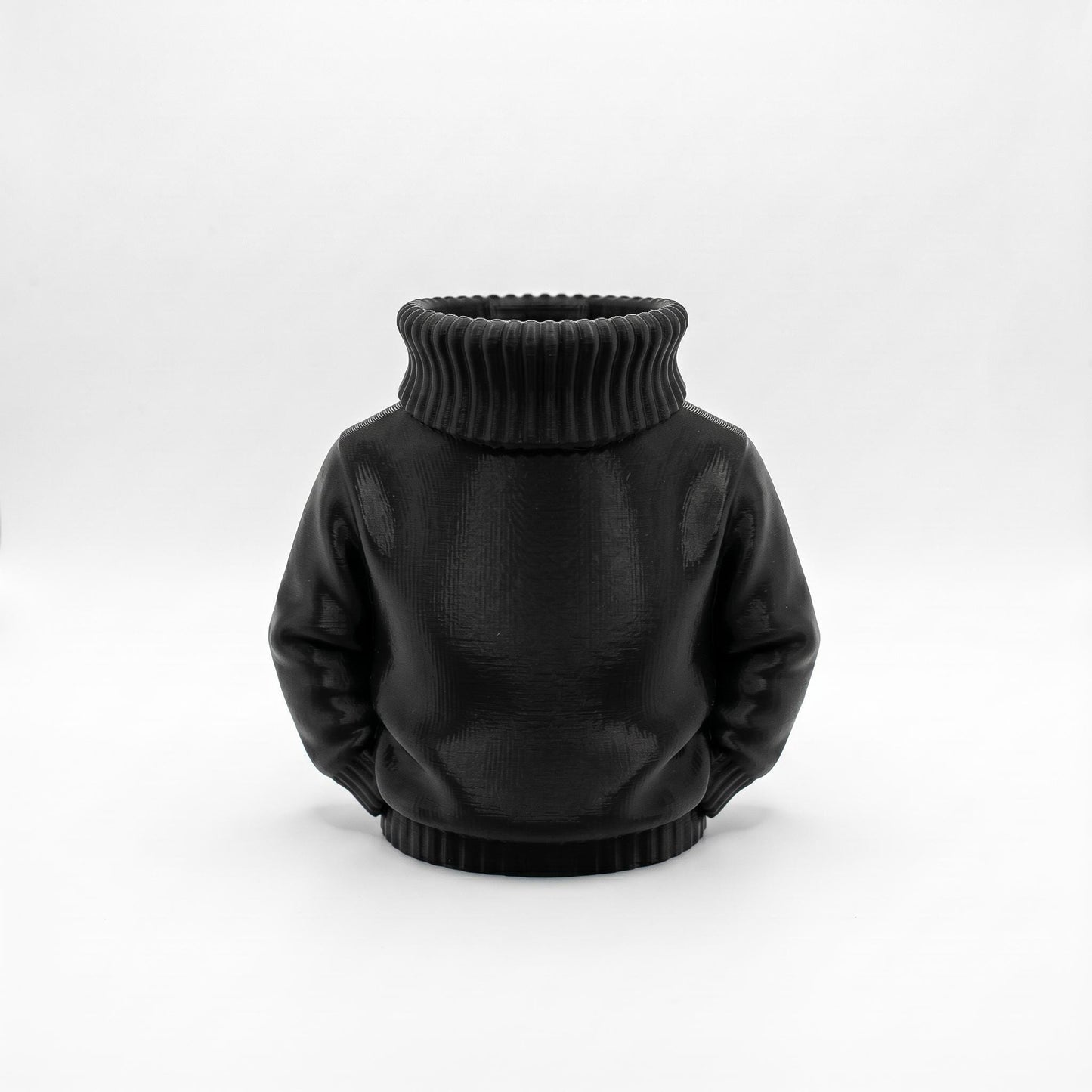 Schwarzer 3D-gedruckter Stiftehalter in Form eines Rollkragenpullovers aus mattem PLA-Material. Der miniaturisierte Pullover mit geripptem Kragen und Saum dient als origineller Schreibtisch Organizer für Stifte und Büromaterial. Perfektes Abschiedsgeschenk für Lehrerin oder Erzieherin, auch ideal als Schulgeschenk oder Schultüte Inhalt. Maße: 11×10×7 cm, ca. 90g. Funktionale Desk Deko die Ordnung und Stil vereint.