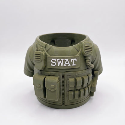 3D-gedruckter SWAT Stiftehalter in oliv-grüner Farbe mit detailgetreuen taktischen Elementen. Der runde Behälter zeigt eine realistische Schutzweste mit SWAT-Aufschrift, Ausrüstungstaschen, Funkgerät und Patronengurt. Perfekter Schreibtisch Organizer aus robustem PLA-Material. Ideales Abschiedsgeschenk für Lehrerin oder Erzieherin, auch als Schulgeschenk oder Mitgebsel geeignet. Maße: 11×10×7 cm, ca. 90g schwer.
