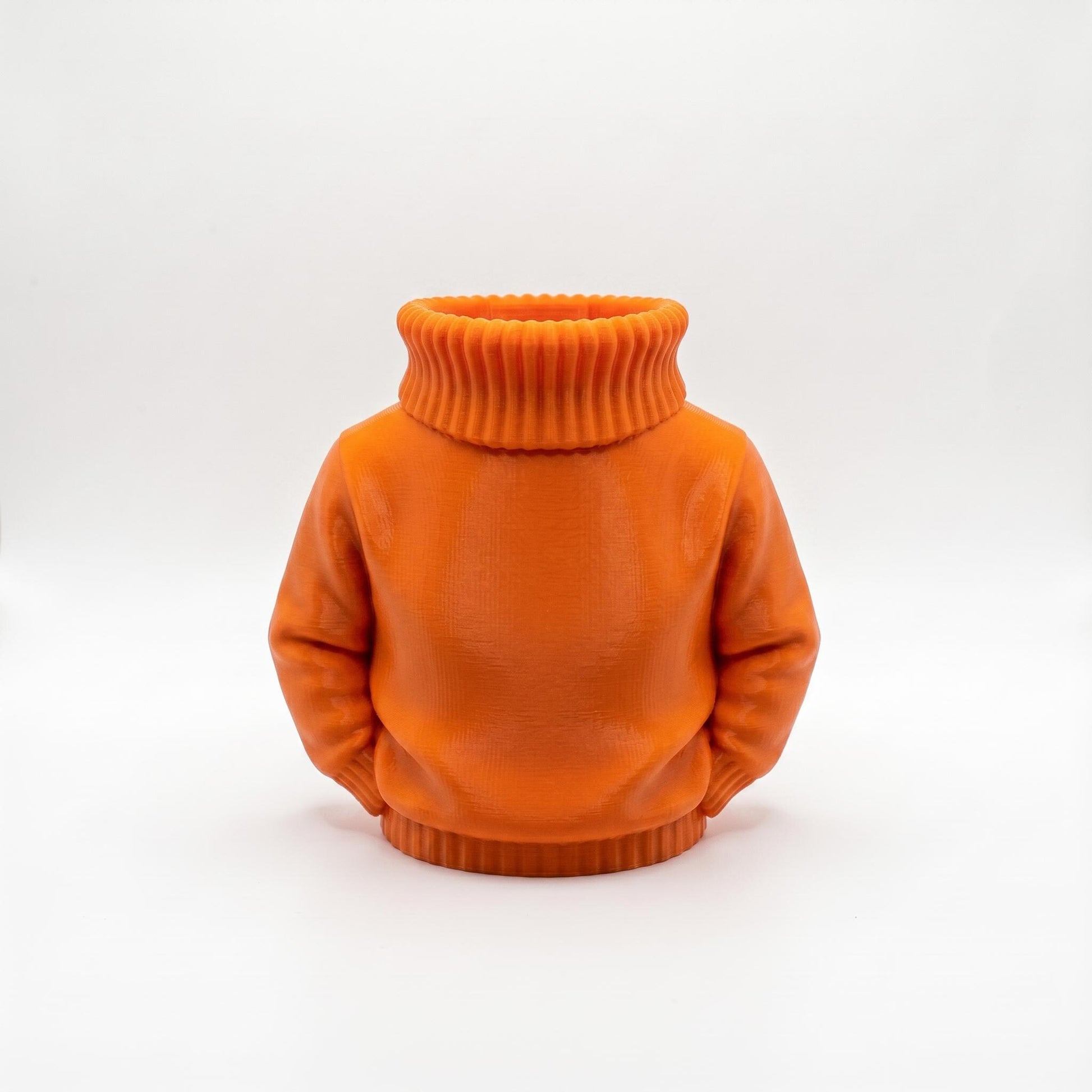 Ein 3D-gedruckter Stiftehalter in leuchtend orangefarbener Ausführung im kreativen Pullover-Design mit hochgezogenem Rollkragen. Der aus PLA gefertigte Desk Organizer misst 11×10×7 cm und bietet praktischen Stauraum für Stifte und Büromaterial. Perfekt als Abschiedsgeschenk für Lehrerin oder Erzieherin, Schulgeschenk zur Einschulung oder originelle Schreibtisch-Deko. Die matte Oberfläche verleiht dem 3D Druck einen hochwertigen Look.