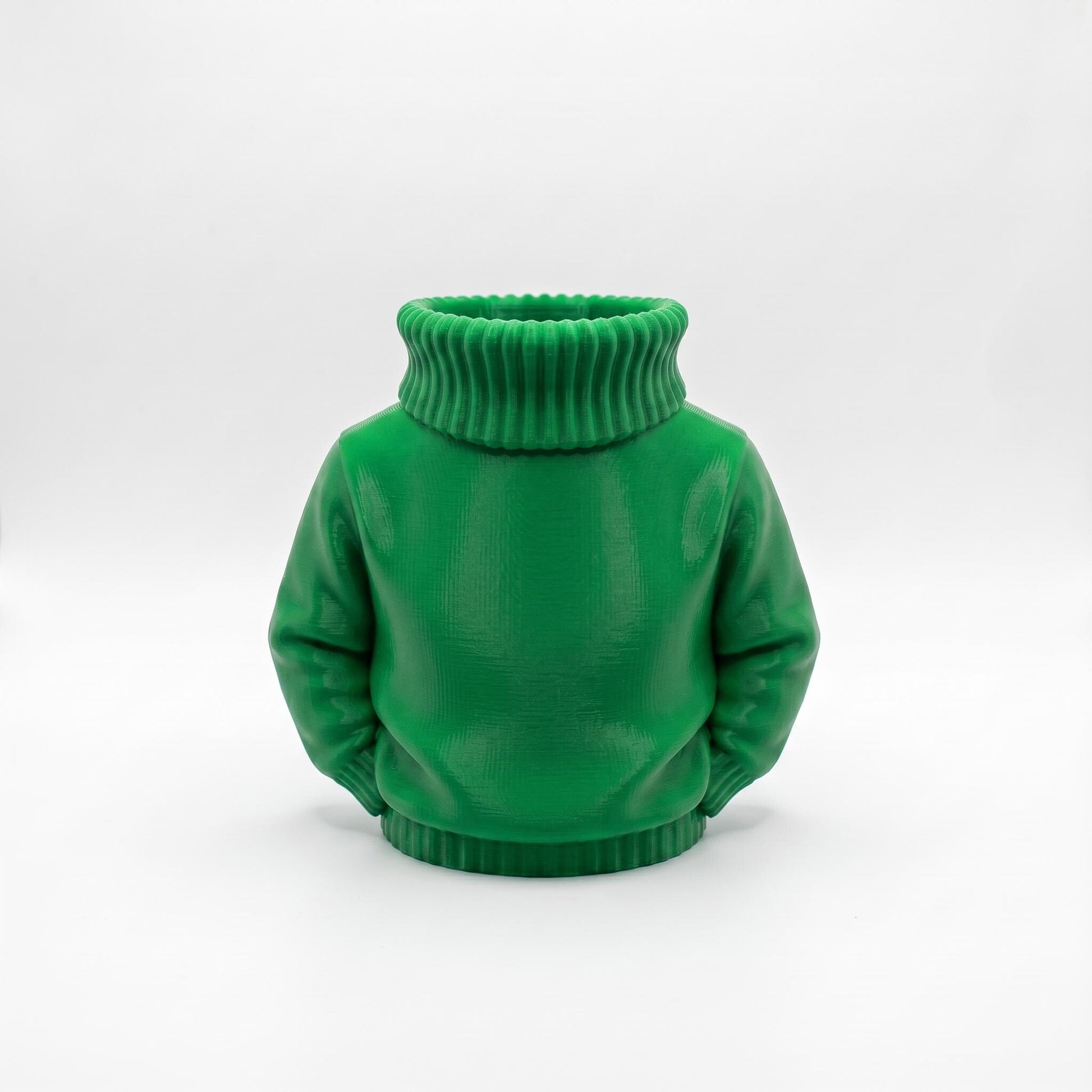 Ein grüner 3D-gedruckter Stiftehalter in Form eines Rollkragenpullovers steht vor hellem Hintergrund. Das detailreich gestaltete Desk Organizer zeigt realistische Pullover-Struktur mit geripptem Rollkragen und Ärmeln. Der Schreibtisch Organizer aus PLA-Material eignet sich perfekt als Abschiedsgeschenk Lehrerin oder Erzieherin, Schulgeschenk zur Einschulung oder als einzigartige Büro-Dekoration. Maße: 11×10×7 cm.