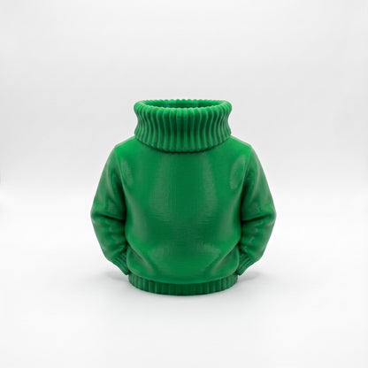 Ein grüner 3D-gedruckter Stiftehalter in Form eines Rollkragenpullovers steht vor hellem Hintergrund. Das detailreich gestaltete Desk Organizer zeigt realistische Pullover-Struktur mit geripptem Rollkragen und Ärmeln. Der Schreibtisch Organizer aus PLA-Material eignet sich perfekt als Abschiedsgeschenk Lehrerin oder Erzieherin, Schulgeschenk zur Einschulung oder als einzigartige Büro-Dekoration. Maße: 11×10×7 cm.