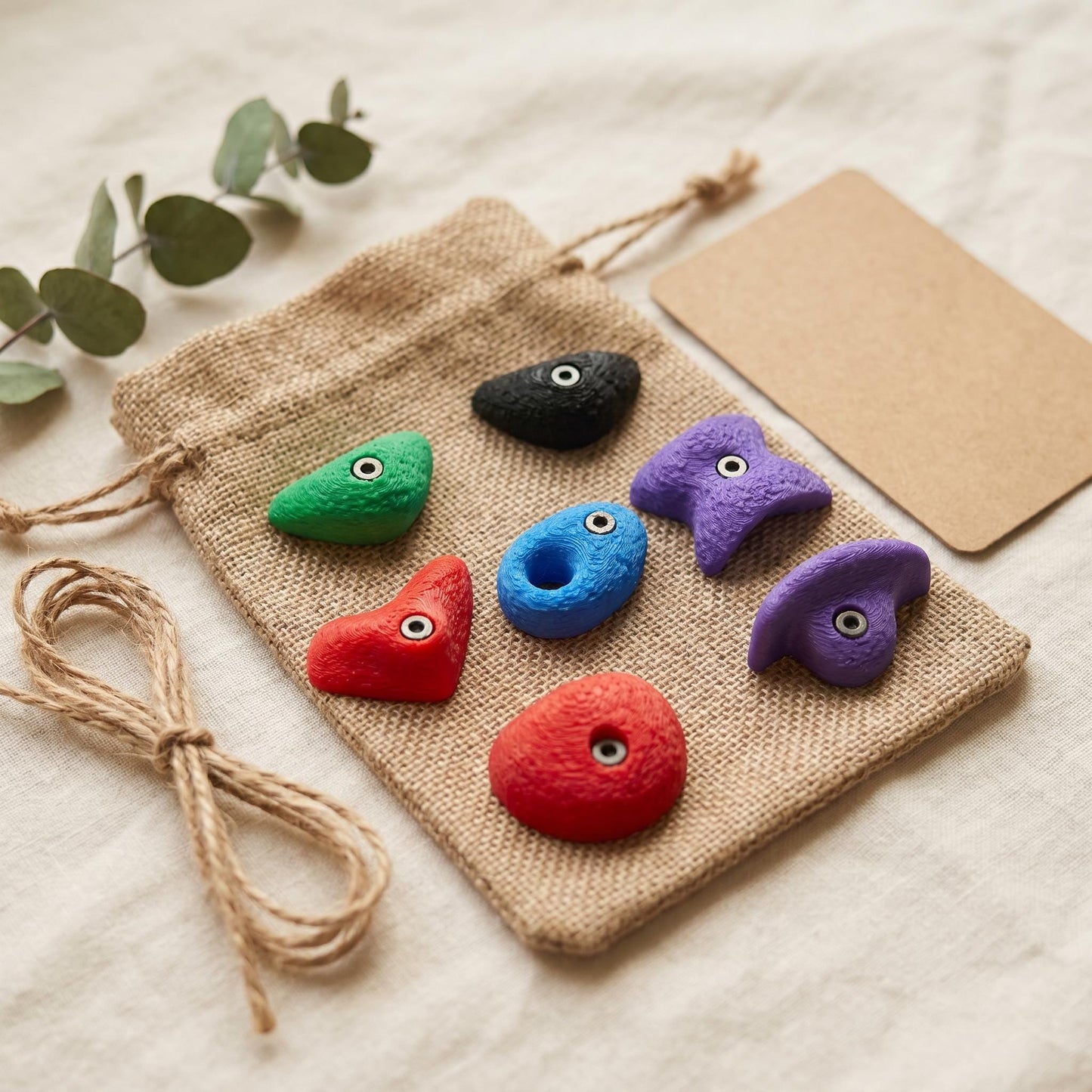 Bouldergriff-Magnete-Set in einem Jutesäckchen neben Eukalyptus und Kraft-Karte — geschenkfertig verpackt für Kletter-Fans und Boulderer.