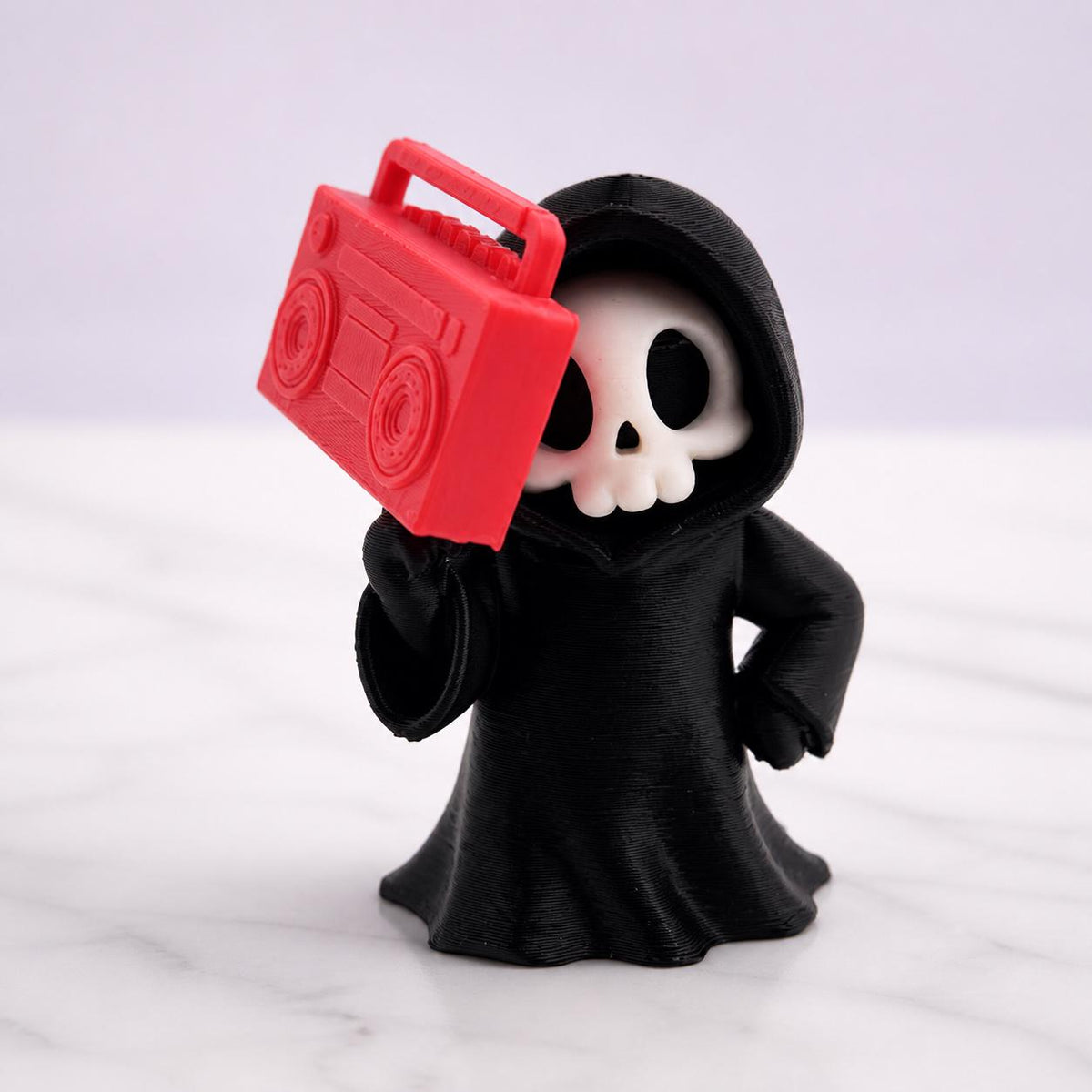 3D-gedruckte Gothic Sensenmann-Figur aus PLA mit sichtbaren feinen Druckschichten als bewusstem Teil der Oberfläche; Nahaufnahme von Kapuze, Gesicht und Boombox-Details.