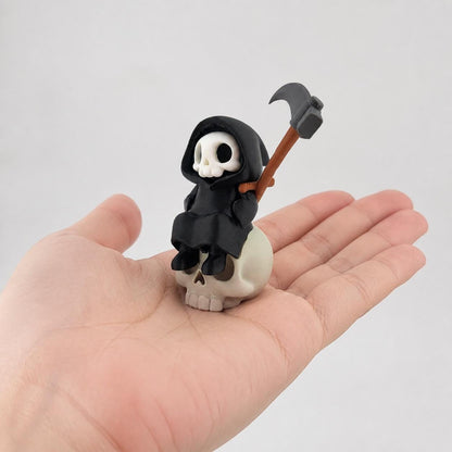 3D-gedruckte Gothic Sensenmann-Figur aus PLA mit sichtbaren feinen Druckschichten als bewusstem Teil der Oberfläche; Figur in einer erwachsenen Hand zur Größenorientierung.