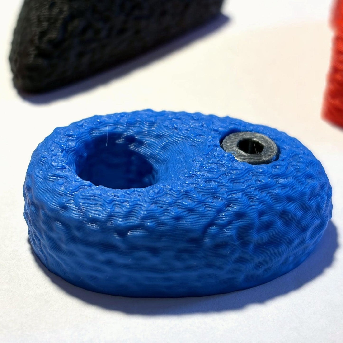 Makroaufnahme des blauen Pocket-Griffs: durchgehendes Griffloch, feine 3D-Druck-Schichtlinien und die vertiefte Inbus-Optik aus Silk-PLA in Metallic-Look. Der Neodym-Magnet ist vollständig im Druck eingeschlossen.
