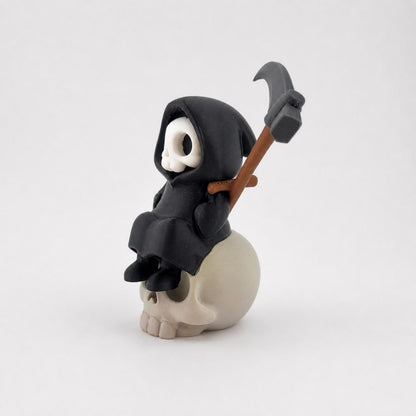 3D-gedruckte Gothic Sensenmann-Figur aus PLA mit sichtbaren feinen Druckschichten als bewusstem Teil der Oberfläche; alternative Seitenansicht der Figur auf dem Schädel.
