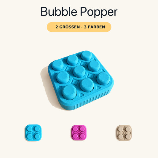Türkiser 3×3 Bubble Popper mit neun Druckflächen auf cremefarbenem Hintergrund; darunter Farbbeispiele in Türkis, Magenta und Latte-Braun.
