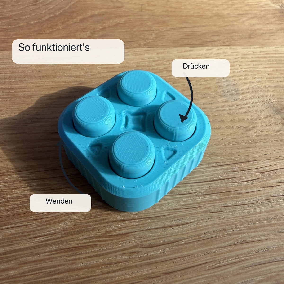 Nahaufnahme eines türkisen 2×2 Bubble Popper Fidgets mit Pfeilen, die das Drücken und anschließende Wenden des Spielzeugs erklären.
