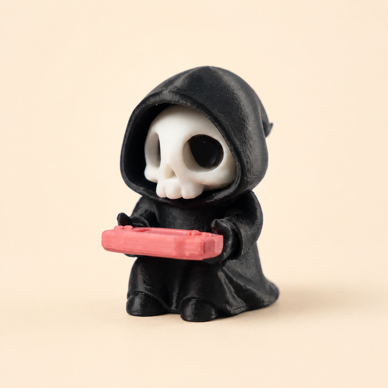 Sensenmann mit Konsole – Gothic Gaming-Figur – Produktfoto auf warmem Creme-Hintergrund