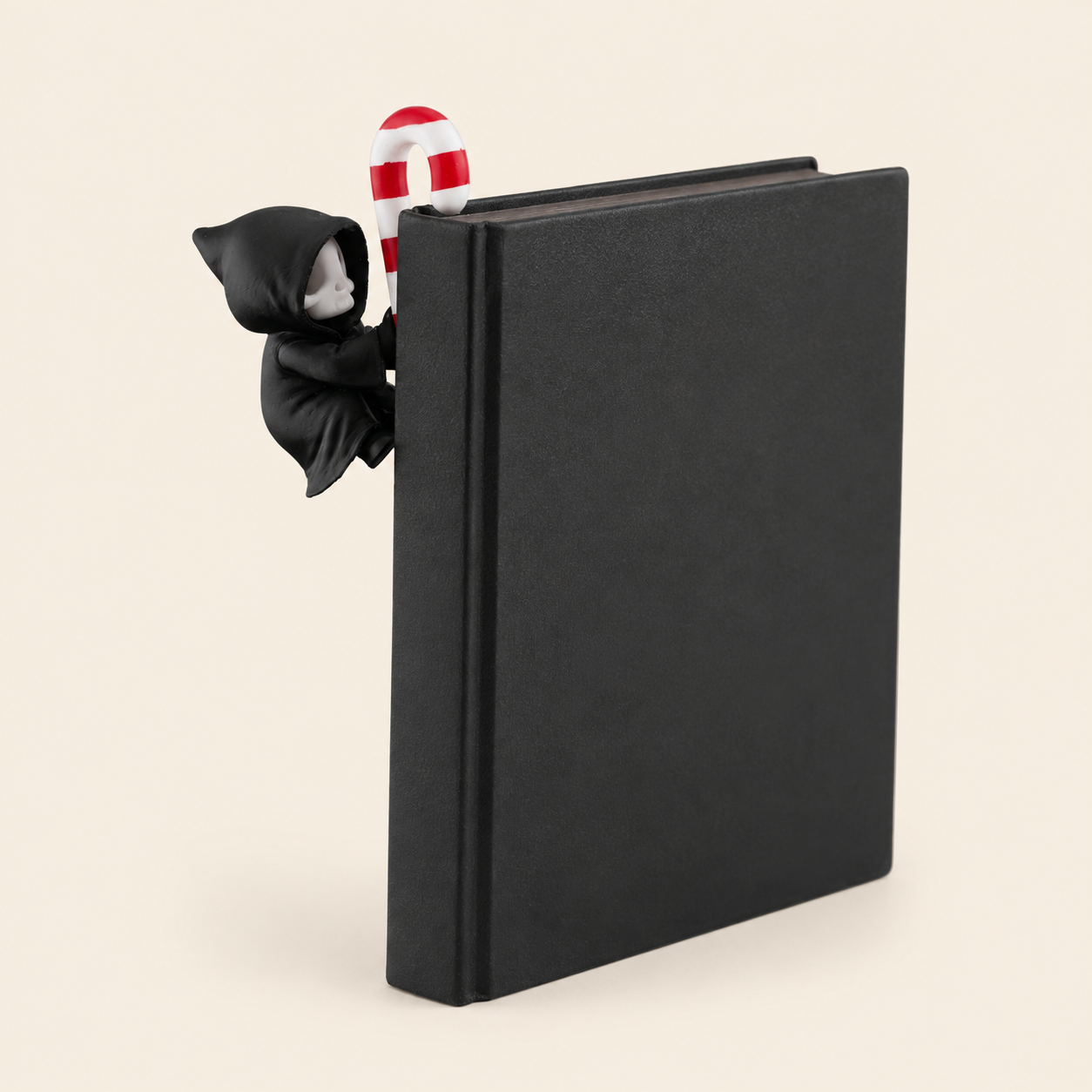 Sensenmann als Buchkanten-Figur – Gothmas Bücherregal-Deko – Produktfoto auf warmem Creme-Hintergrund