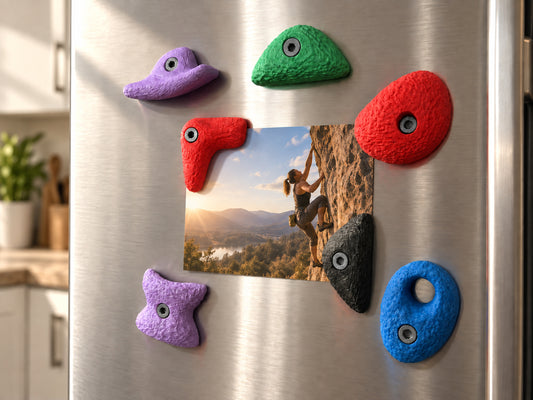 Sieben große Bouldergriff-Magnete im Farbmix an einer Edelstahl-Kühlschranktür rund um ein Foto eines Outdoor-Kletterers.