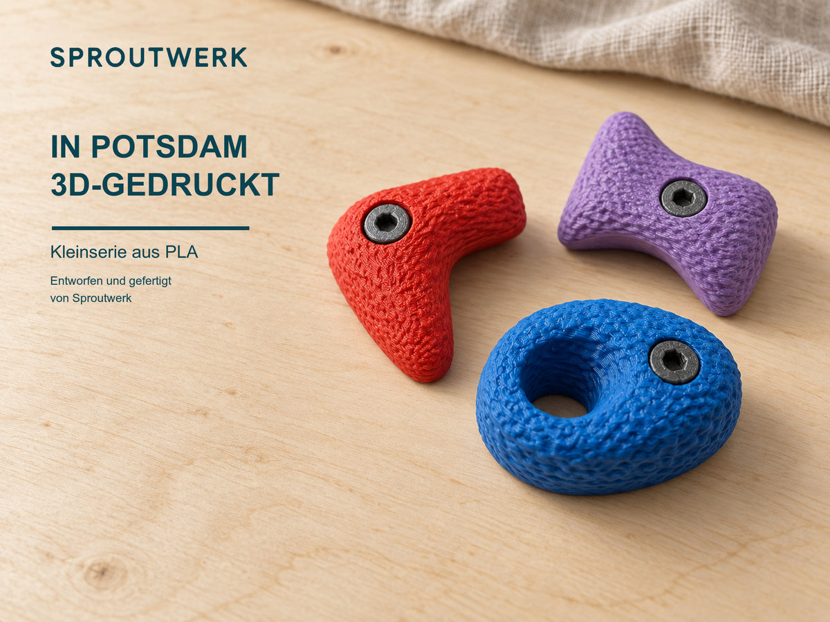 Drei große Bouldergriff-Magnete auf hellem Birkenholz mit dem Hinweis, dass sie als Kleinserie aus PLA in Potsdam von Sproutwerk 3D-gedruckt werden.